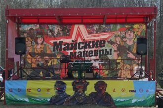 Сцена с ярким баннером «Майские маневры»